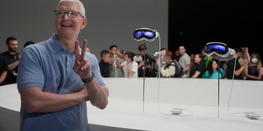 Apple-CEO Tim Cook posiert neben den neuen Vision Pro Headsets auf dem Firmencampus in Cupertino.