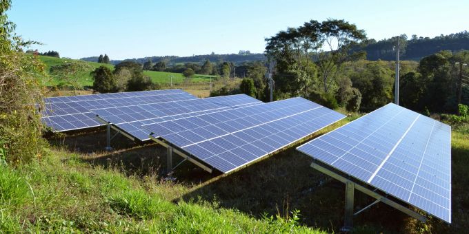 Ein Mann installiert eine Solaranlage auf dem Dach eines Hauses, um Sonnenenergie zu gewinnen. Solarenergie