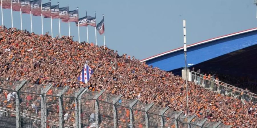 Die niederländischen Zuschauer auf der Tribüne reagieren begeistert auf die Pole Position ihres Landsmanns Max Verstappen in Zandvoort. Foto: Hasan Bratic/dpa