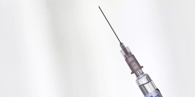 Ein Arzt hält eine Spritze mit einer Grippeimpfung der Influenza-Saison 2020 / 2021 in der Hand. covid 19 grippeimpfung