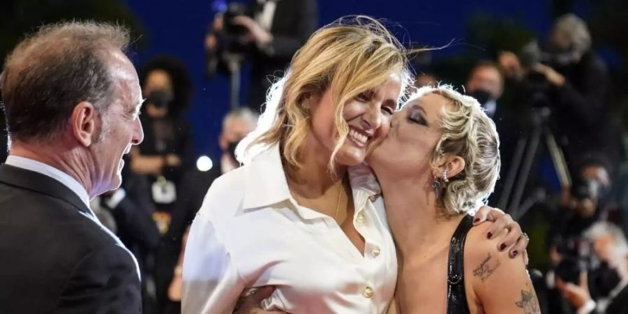 Die Schauspielerin Agathe Rousselle (r) drückt der Regisseurin Julia Ducournau in Cannes ein Küsschen auf. Foto: Brynn Anderson/AP/dpa