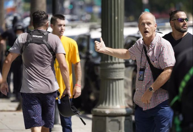 Der KPCC-Reporter Frank Stolze fordert Polizeibeamte zum Eingreifen auf, als er den Park in der Nähe des Rathauses verlässt, nachdem er am Samstag in Los Angeles von Anti-Masken-Demonstranten angegriffen wurde. impfgegner corona