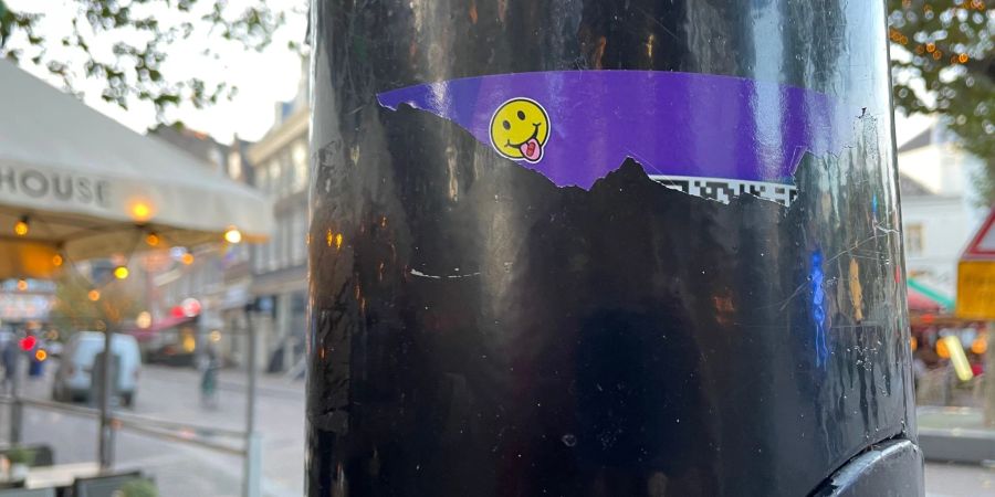 In Amsterdam wurden an öffentlichen Plätzen wie Laternenpfählen Sticker geklebt, über die man mit Hilfe eines QR-Codes Drogen wie XTC online bestellen kann.