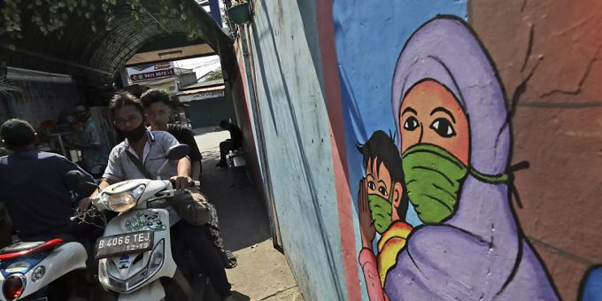 Ein Wandbild in Jakarta zeigt eine Frau und ein Kind, die Mundschutz tragen. Foto: Dita Alangkara/AP/dpa Ein Wandbild in Jakarta zeigt eine Frau und ein Kind, die Mundschutz tragen. Foto: Dita Alangkara/AP/dpa