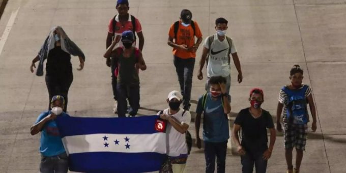 Menschen tragen eine Fahne von Honduras und gehen in der Hoffnung, zukünftig die USA zu erreichen, einen Highway entlang. Foto: Uncredited/AP/dpa Menschen tragen eine Fahne von Honduras und gehen in der Hoffnung, zukünftig die USA zu erreichen, einen Highway entlang. Foto: Uncredited/AP/dpa