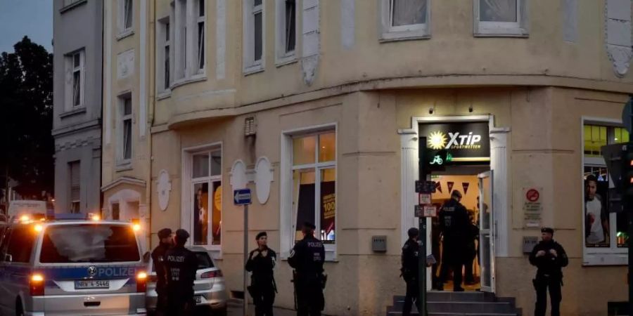 Polizisten stehen während einer Razzia vor einem Wettbüro. Foto: Caroline Seidel/dpa