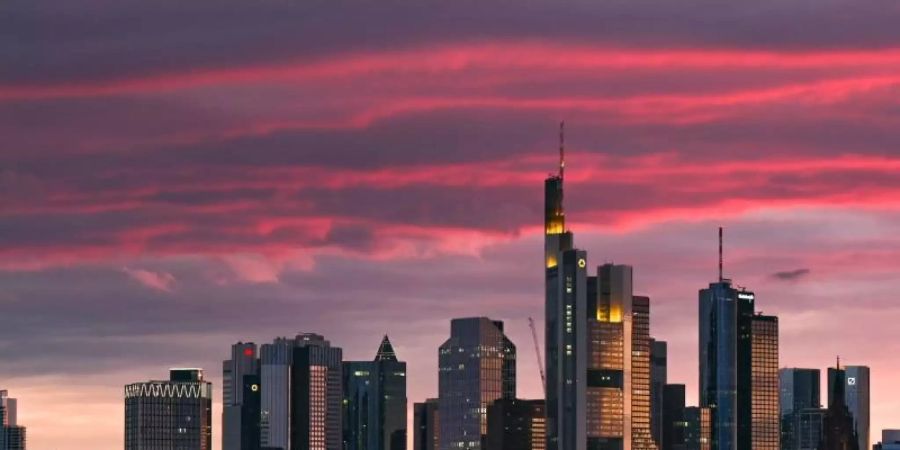 Bei Sonnenuntergang ist die Skyline der Bankenstadt in rötliches Licht getaucht. Foto: Arne Dedert/dpa