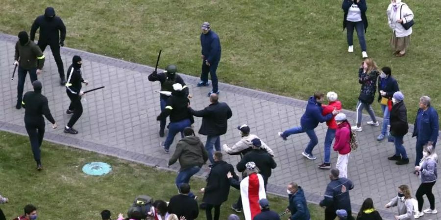 Demonstranten und Polizisten in Zivil geraten in Minsk aneinander. Foto: Uncredited/AP/dpa