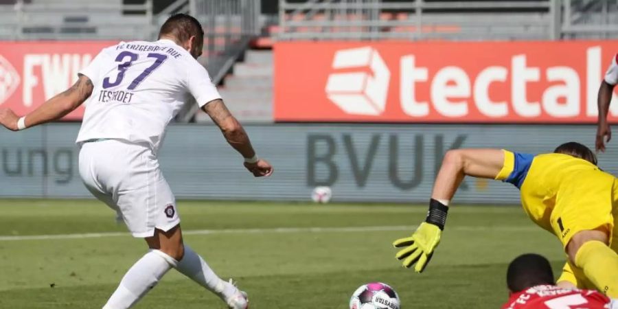 Pascal Testroet (l) von Erzgebirge Aue schiesst den Ball zum 2:0 gegen die Würzburger Kickers ins Tor. Foto: Daniel Karmann/dpa