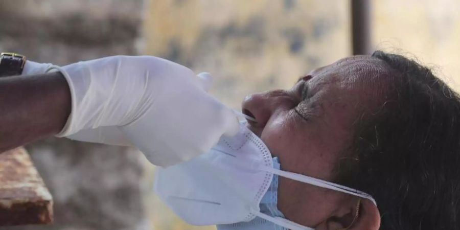 Ein medizinischer Mitarbeiterin der indischen Stadt Hyderabad entnimmt einer Frau einen Nasenabstrich für einen Corona-Test. Foto: Mahesh Kumar A/AP/dpa