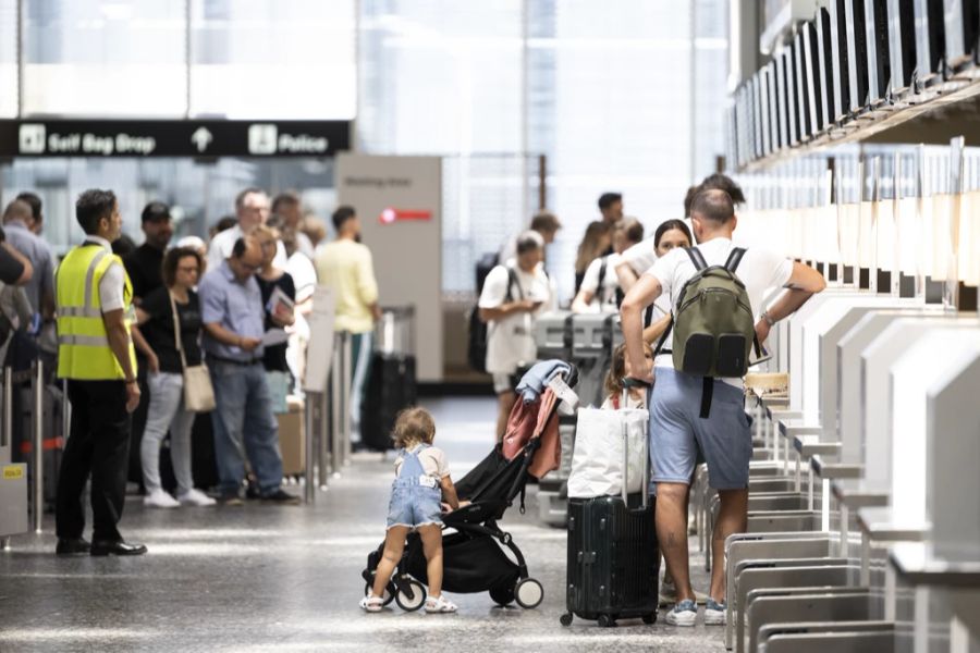 Menschen warten am Flughafen auf ihren Abflug in die Ferien.