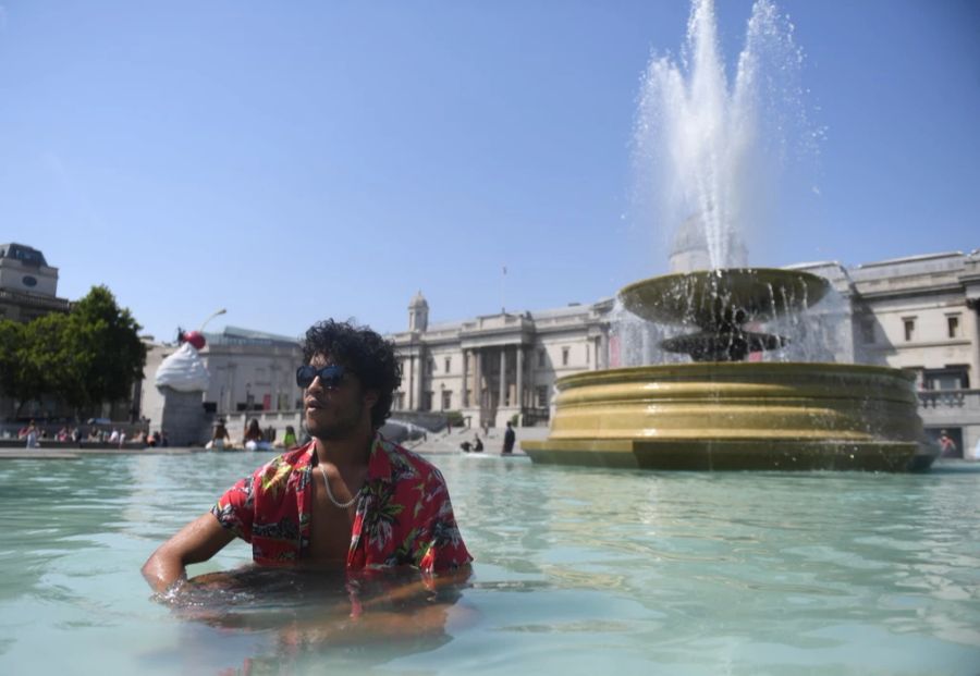 Ein Mann kühlt sich im Brunnen am Trafalgar Square in London ab.