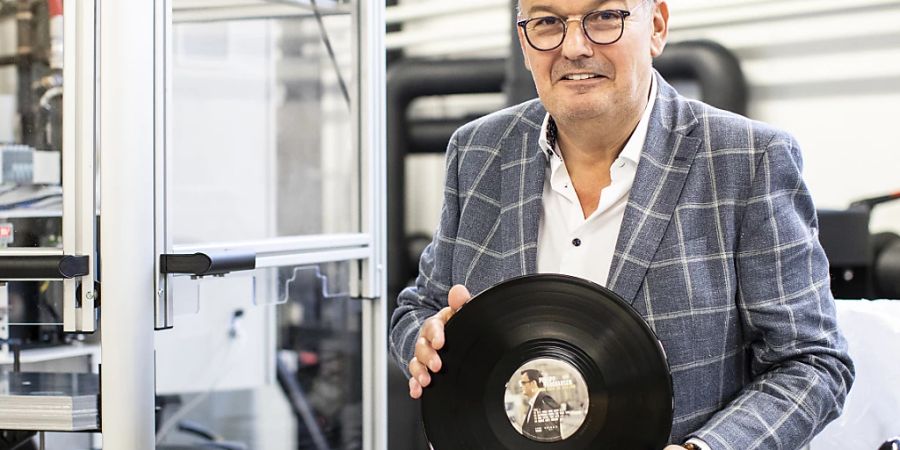 Musiker Philipp Fankhauser steht neben einer neuen Vinylpresse bei Adon in Neuenhof AG.