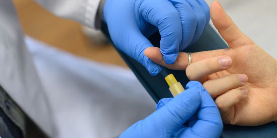 Ein Mitarbeiter der Aids-Hilfe Sachsen-Anhalt demonstriert im Labor die Blutentnahme für einen HIV-Test.