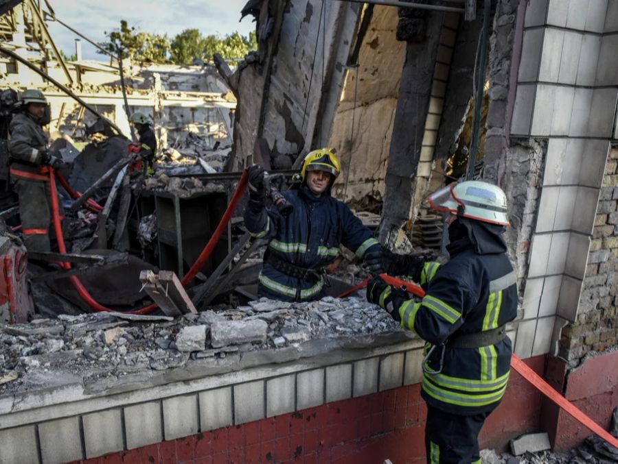 Feuerwehrmänner bei einer Reparaturanlage für Schienenfahrzeuge in der Nähe von Kiew.