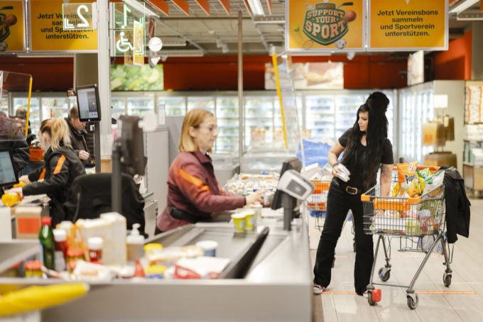 Eine Frau kauft im Migros ein. Detailhandel migros