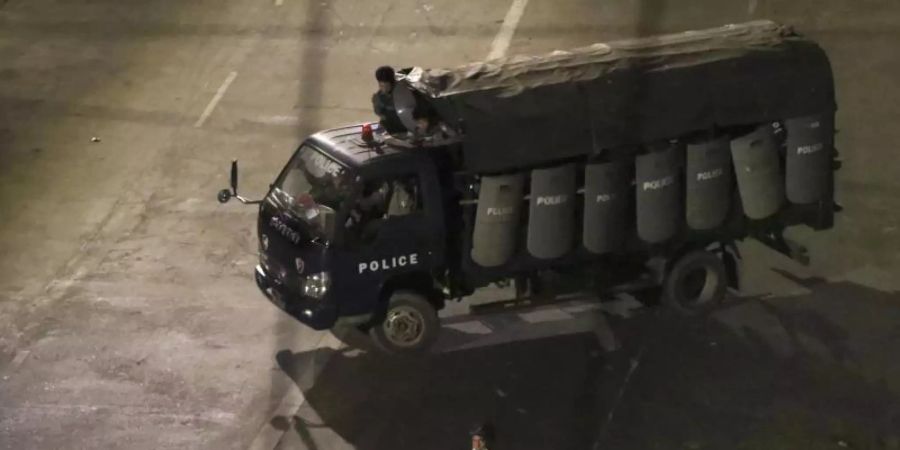 Polizisten sitzen in einem Lastwagen und fahren Patrouille in Yangon. Foto: Uncredited/AP/dpa