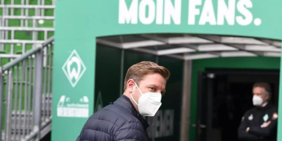 Werders Trainer Florian Kohfeldt (l) geht aus dem Innenraumbereich in die Kabine, im Hintergrund steht Geschäftsführer Frank Baumann. Foto: Carmen Jaspersen/dpa