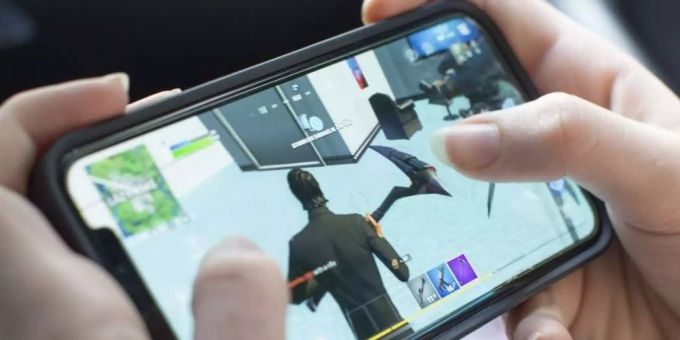 Eine Person zockt auf einen iPhone Fortnite von Epic Games. fortnite