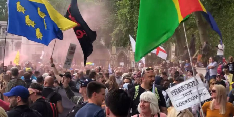 Demonstranten nehmen auf dem Parliament Square mit Fahnen an einem Protest gegen die Corona-Impfungen teil. Foto: Tess De La Mere/PA Wire/dpa