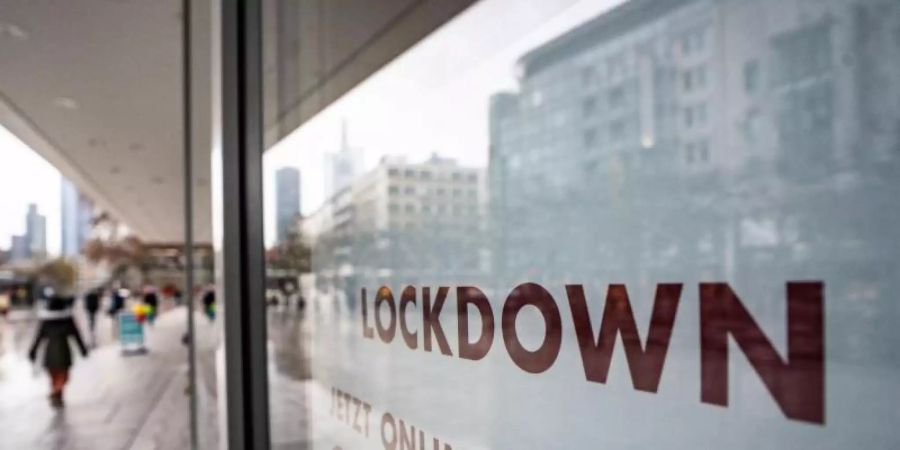 «Lockdown» steht im Schaufenster eines geschlossenen Kaufhauses, das darunter zum Online-Einkauf rät. Foto: Frank Rumpenhorst/dpa