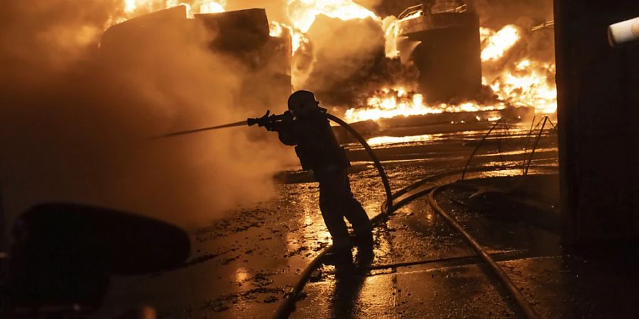 Feuerwehrleute löschen ein Feuer nach einem russischen Angriff auf ein Wohnviertel. Foto: Yevhen Titov/AP/dpa