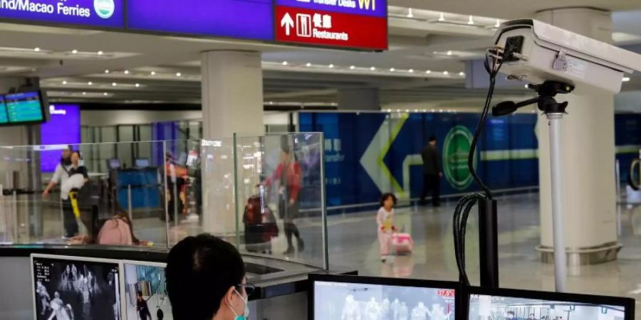 Fieberkontrollen am Flughafen von Hongkong. Foto: Andy Wong/AP/dpa