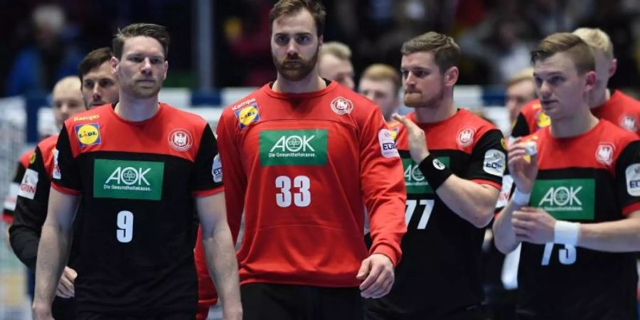Die deutschen Handballer um Torhüter Andreas Wolff (M) verlassen nach dem Abpfiff enttäuscht den Platz. Foto: Robert Michael/dpa-Zentralbild/dpa