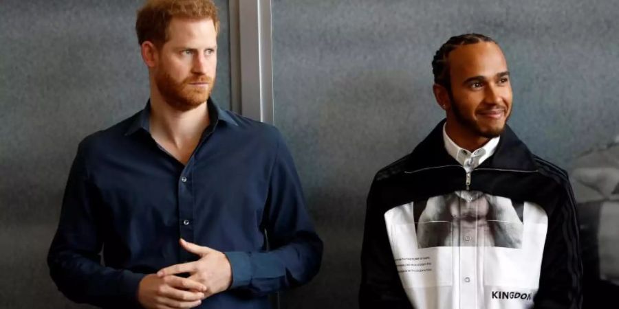 Prinz Harry (l) und Lewis Hamilton bei der Eröffnung des Automobilsport-Museums «The Silverstone Experience». Foto: Peter Nicholls/PA Wire/dpa