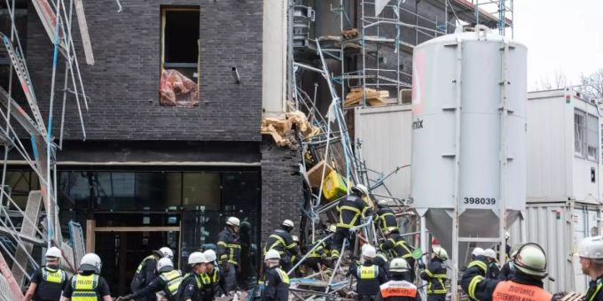 Einsatzkräfte sichern das eingestürzte Gerüst an der Baustelle. Foto: Daniel Bockwoldt/dpa