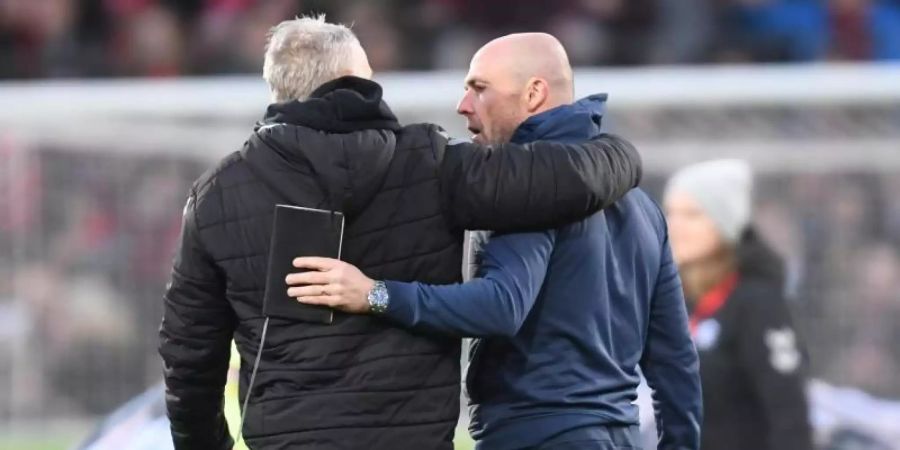 Trainer Alfred Schreuder (r) von 1899 Hoffenheim (r) gratuliert nach dem Spiel seinem Freiburger Kollegen Christian Streich zum Sieg. Foto: Patrick Seeger/dpa