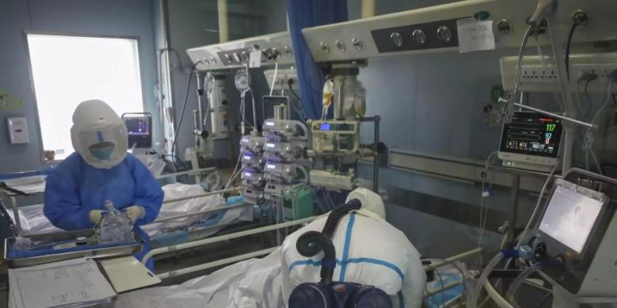Medizinisches Personal untersucht den Zustand eines Patienten im Krankenhaus Jinyintan in Wuhan. Foto: Uncredited/CHINATOPIX/AP/dpa