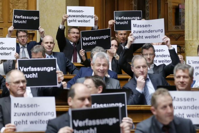 Nationalräte der SVP halten Plakate mit der Aufschrift «Verfassungsbruch» und «Massenzuwanderung geht weiter» hoch, bei der Schlussabstimmung über die Masseneinwanderungsinitiative im Nationalrat, während der Wintersession der Eidgenössischen Räte, am Freitag, 16. Dezember 2016 in Bern. Verfassungsbruch SVP Masseneinwanderungsinitiative