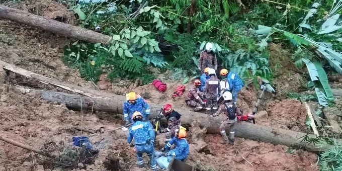 Mitarbeiter des Zivilschutzes suchen in Batang Kali nach Überlebenden. Malaysia