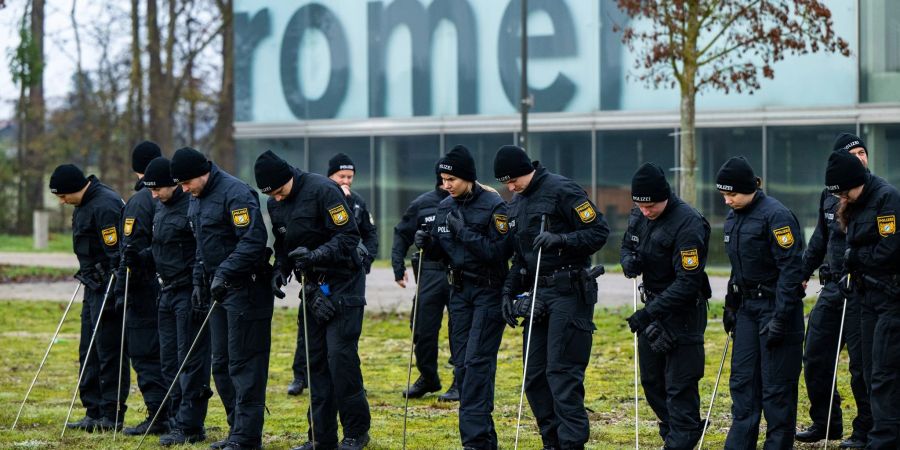 Einsatzkräfte der Bereitschaftspolizei suchen die Umgebung des Museums nach möglichen Spuren ab.