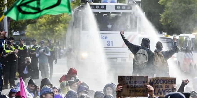 Die Polizei setzt Wasserwerfer gegen Klimaaktivisten ein, die erneut auf der Fahrbahn der A12 nahe Den Haag protestieren. Foto: Remko De Waal/ANP/dpa klima blockade
