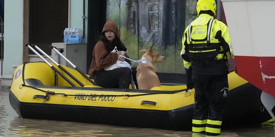 dpatopbilder - Feuerwehrleute retten eine Anwohnerin und ihren Hund. Nach den schweren Unwettern mit heftigen Regenfällen in der mittelitalienischen Region Toskana ist die Zahl der Todesopfer gestiegen. Foto: Gregorio Borgia/AP/dpa