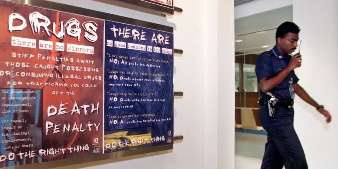 Ein Polizist aus Singapur läuft an einem Anti-Drogen-Poster vorbei. singapur
