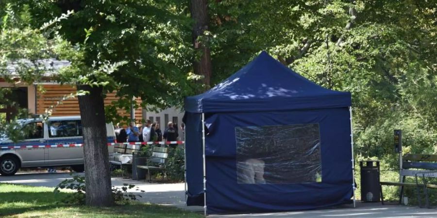 Polizisten sichern in einem Faltpavillon Spuren am Tatort. Foto: Paul Zinken