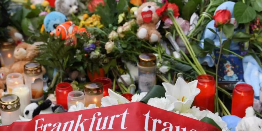 Ein Band mit der Aufschrift «Frankfurt trauert» liegt neben Blumen und Kerzen an Gleis 7 des Frankfurter Hauptbahnhofs. Foto: Arne Dedert