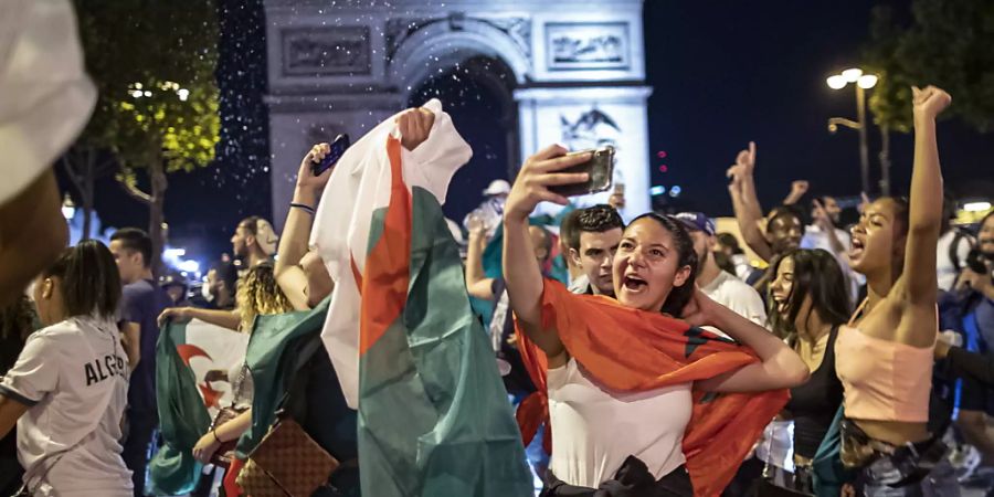 Ausgelassener Jubel: Algerische Fussballfans feiern vor dem Arc de Triomphe in Paris