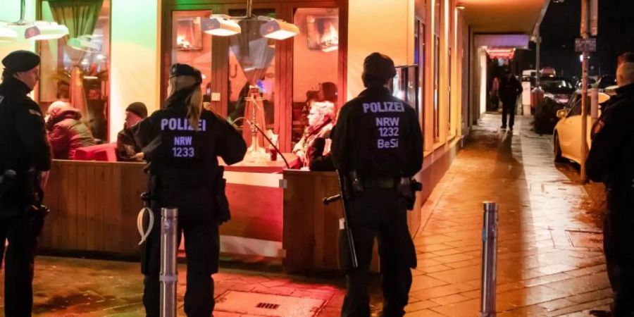 Polizisten sichern während einer Razzia von Zoll und Polizei eine Shisha-Bar. Foto: Bernd Thissen/Illustration