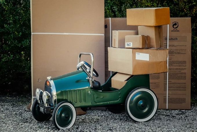 Ein Umzugsunternehmen hat das passende Fahrzeug. Auto und Umzugskartons