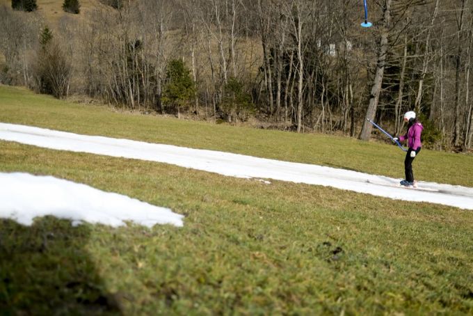 Eine Skifahrerin auf einem Skilift in Leukerbad VS. SChnee