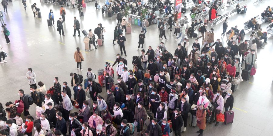 Zahlreiche Fahrgäste stehen in einem Bahnhof in der südchinesischen Provinz Guangdong Schlange.