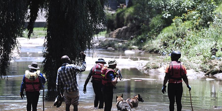 Rettungskräfte suchen Täuflinge, die sich am Ufer des Jukskei-Flusses versammelt hatten und von einer plötzlichen Sturzflut überrascht wurden. Foto: -/AP/dpa