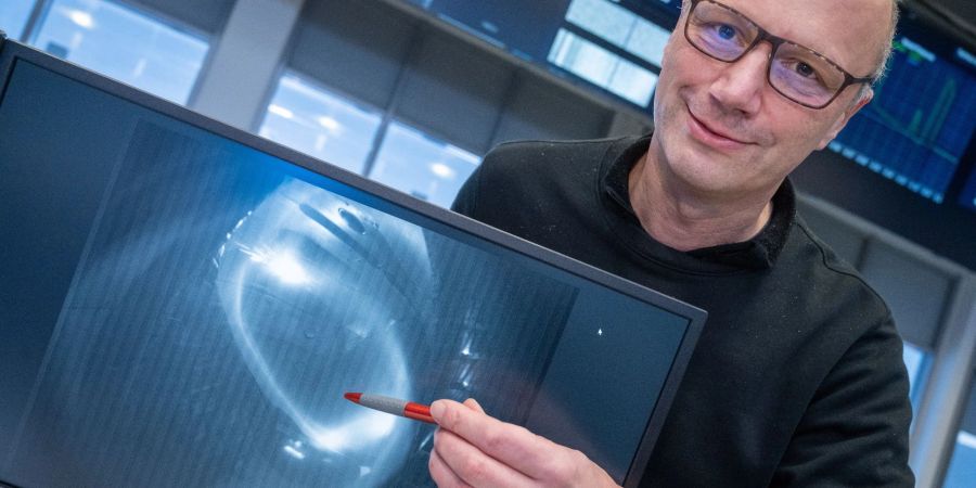 Thomas Klinger, Direktor am Max-Planck-Institut für Plasmaphysik, zeigt ein Bild eines Wasserstoffplasma.