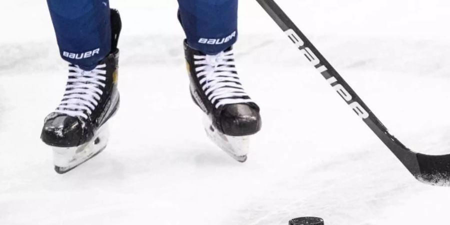 Ein Eishockeyspieler spielt den Puck. Foto: Matthias Balk/dpa