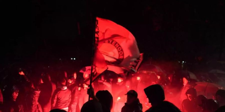 Feyenoord-Fans entzünden Bengalos auf dem Weg zum Berliner Olympiastadion. Foto: Jörg Carstensen/dpa