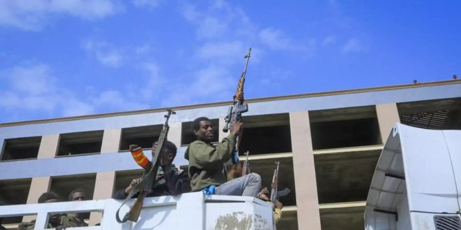 Bewaffnete Tigray-Streitkräfte begleiten gefangene äthiopische Regierungssoldaten und verbündete Milizangehörige in offenen Lastwagen in eine Haftanstalt. Foto: Uncredited/AP/dpa